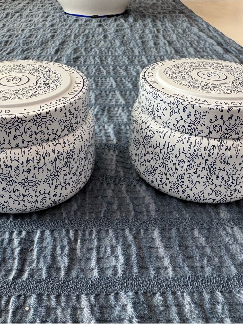 2 White & Navy Decorative tins with Capri Blue candles in Aloha Orchid